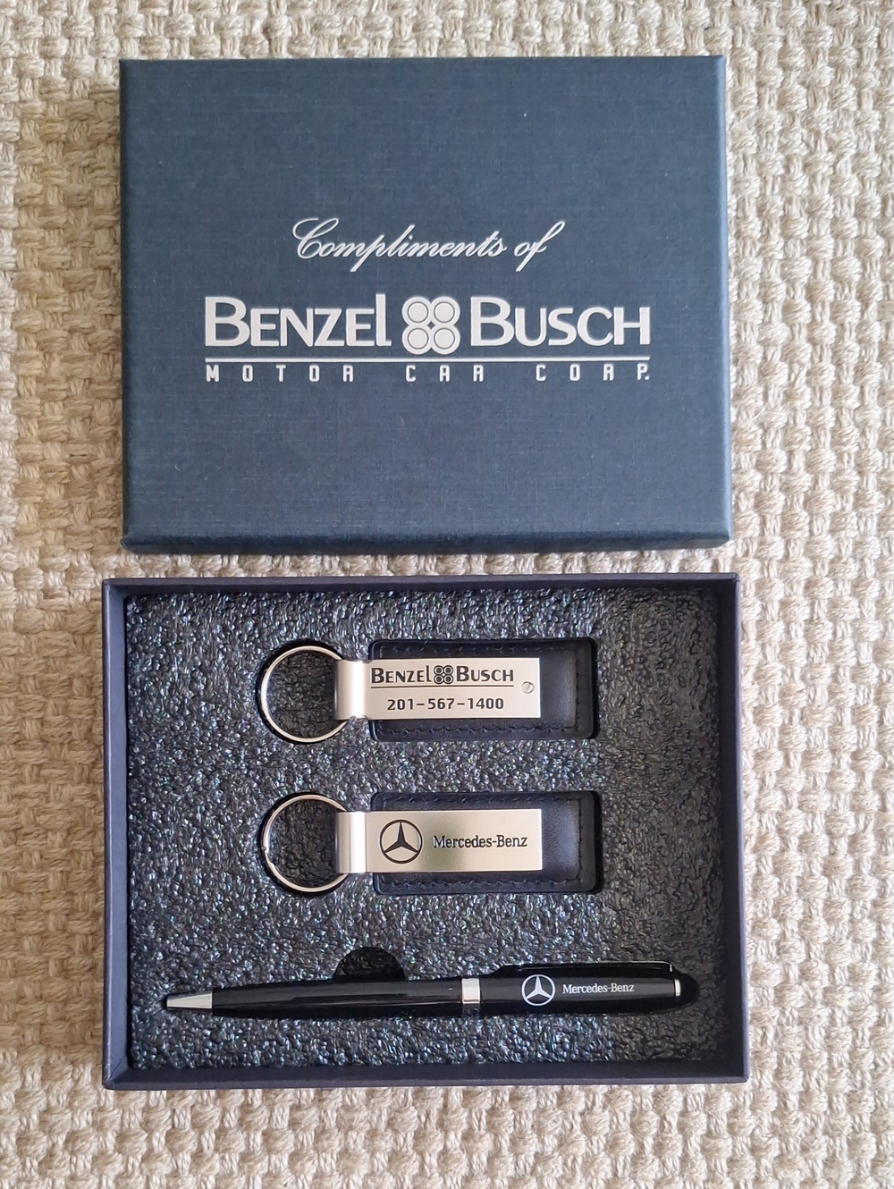 The seMercedes-Benz branded gift set featuring two keychains and a ballpoint pen